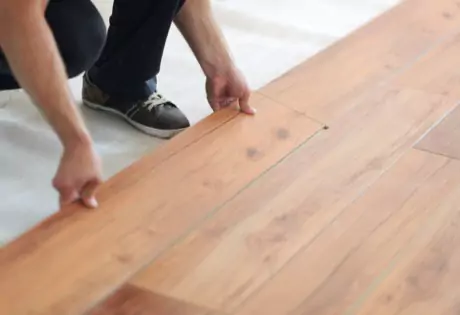 Worker installing flooring | Lions Floor