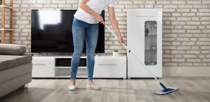 Lady sweeping laminate flooring | Lions Floor